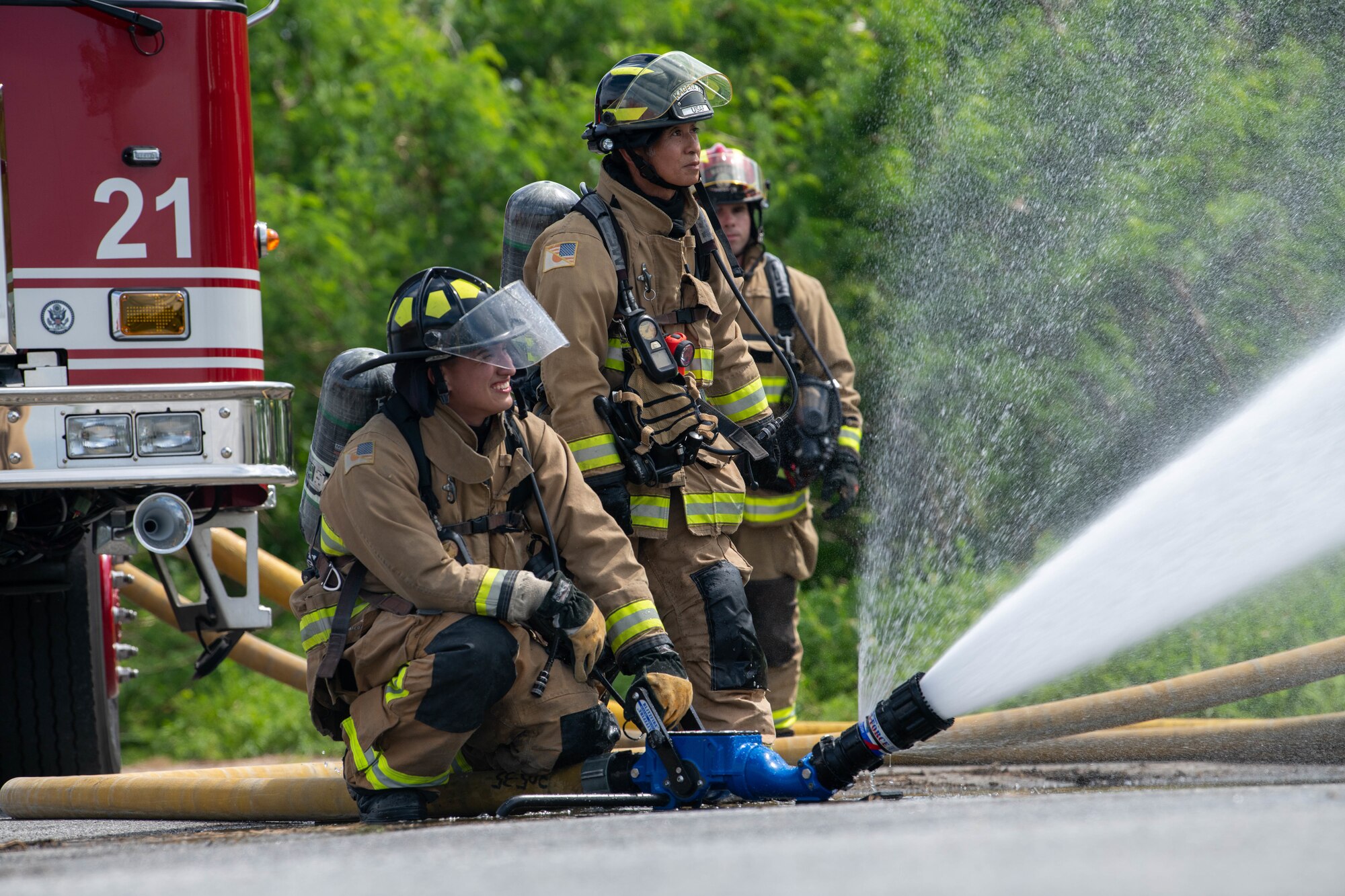 Firemen use Hose to dowse training structure