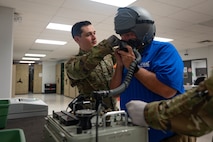 U.S. Air Force Senior Airman Evan Petrosky, 5th Operations Support Squadron aircrew flight equipment (AFE) technician, sizes flight equipment for the Honorable Tom Ross, mayor of Minot, North Dakota, at Minot Air Force Base, North Dakota, Sept. 5, 2023. Using the Scot Communications and Oxygen Tester, Petrosky ensures that the flight mask is properly fitted and sealed. (U.S. Air Force photo by Senior Airman Zachary Wright)