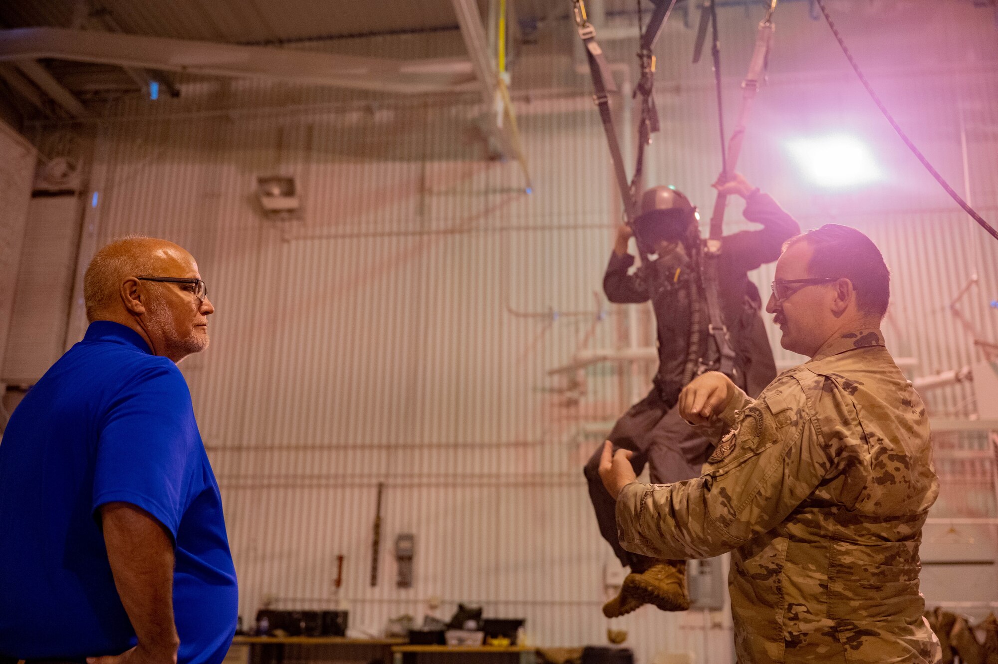 U.S. Air Force Tech. Sgt. Brett Darby, Survival, Evasion, Resistance and Escape (SERE)  specialist, instructs the Honorable Tom Ross, mayor of Minot, North Dakota, on how to operate a parachute at Minot Air Force Base, North Dakota, Sept. 5, 2023. SERE instructors specialize in conducting developmental and operational testing of SERE and Aircrew equipment. (U.S. Air Force photo by Senior Airman Zachary Wright)