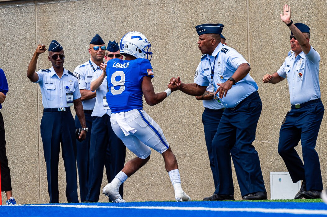 Air Force quarterback Zac Larrier celebrates with Lt. Gen. Richard M. Clark