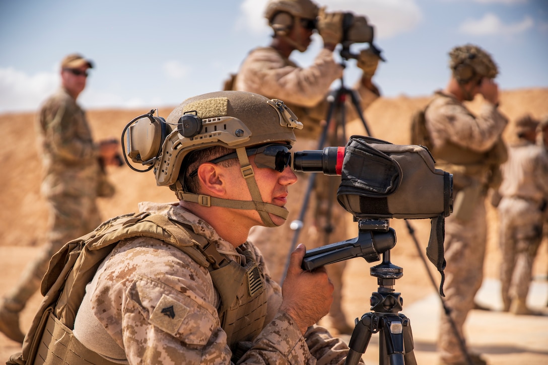 A Marine looks through monoculars.