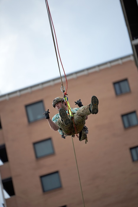 A U.S. Air Force pararescueman executes an urban high-angle ropes scenario to reach a simulated injured service member, render medical care, and lower him to safety during the PJ Rodeo competition in Louisville, Ky., Sept. 6, 2023. The biennial event, which tests the capabilities of pararescue Airmen across the service, was hosted by the Kentucky Air National Guard’s 123rd Special Tactics Squadron. (U.S. Air National Guard photo by Phil Speck)