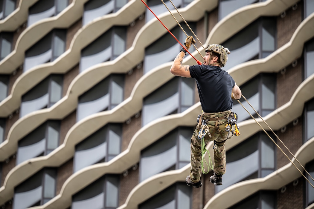 A U.S. Air Force pararescueman executes an urban high-angle ropes scenario to reach a simulated injured service member, render medical care, and lower him to safety during the 2023 PJ Rodeo competition in Louisville, Ky., Sept. 6, 2023. The biennial event, which tests the capabilities of pararescue Airmen across the service, was hosted by the Kentucky Air National Guard’s 123rd Special Tactics Squadron. (U.S. Air National Guard photo by Dale Greer)