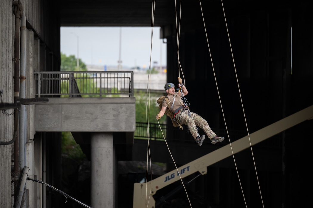 A U.S. Air Force pararescueman executes an urban high-angle ropes scenario to reach a simulated injured service member, render medical care, and lower him to safety during the 2023 PJ Rodeo competition in Louisville, Ky., Sept. 6, 2023. The biennial event, which tests the capabilities of pararescue Airmen across the service, was hosted by the Kentucky Air National Guard’s 123rd Special Tactics Squadron. (U.S. Air National Guard photo by Dale Greer)