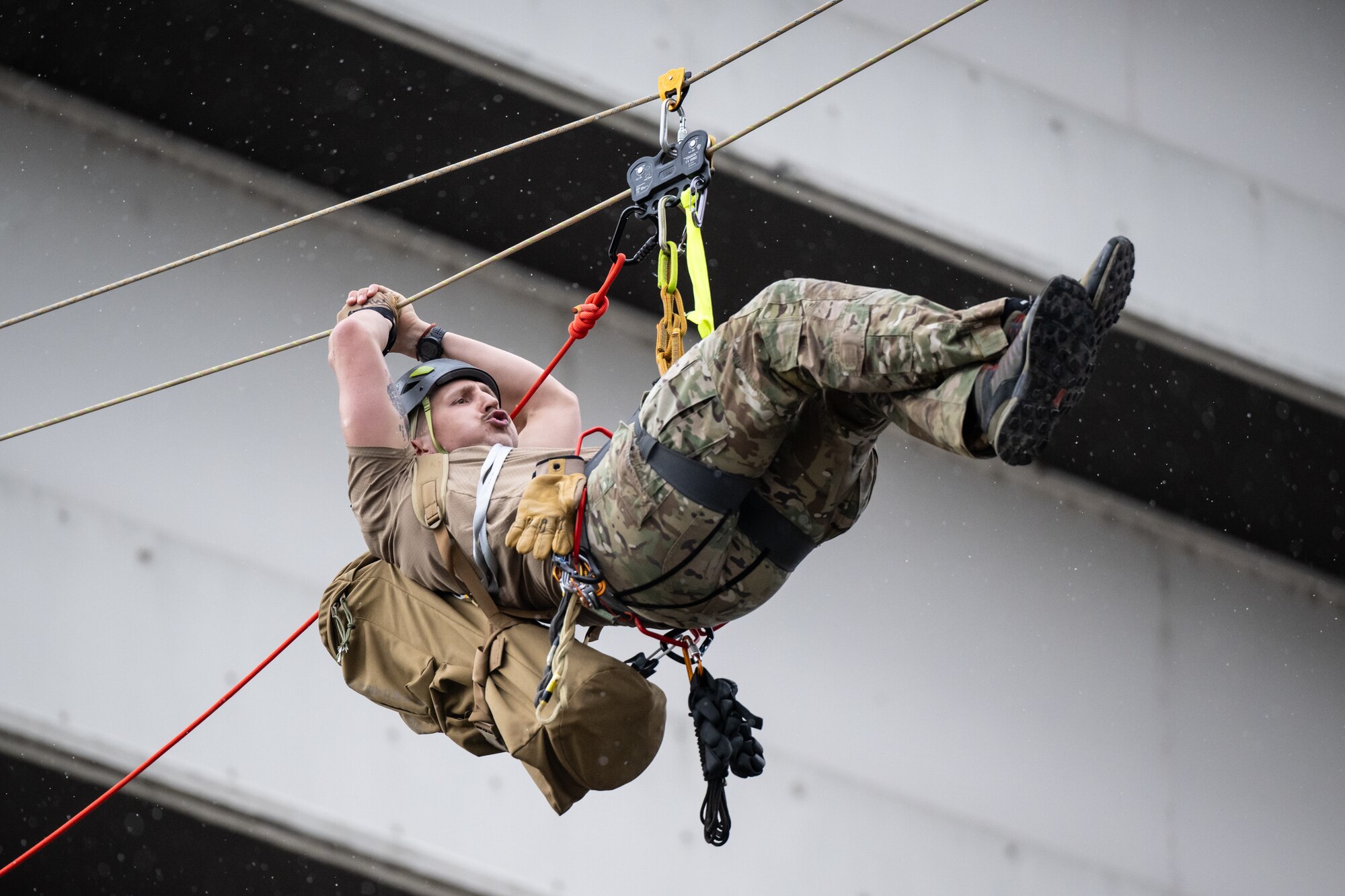 A U.S. Air Force pararescueman executes an urban high-angle ropes scenario to reach a simulated injured service member, render medical care, and lower him to safety during the 2023 PJ Rodeo competition in Louisville, Ky., Sept. 6, 2023. The biennial event, which tests the capabilities of pararescue Airmen across the service, was hosted by the Kentucky Air National Guard’s 123rd Special Tactics Squadron. (U.S. Air National Guard photo by Dale Greer)