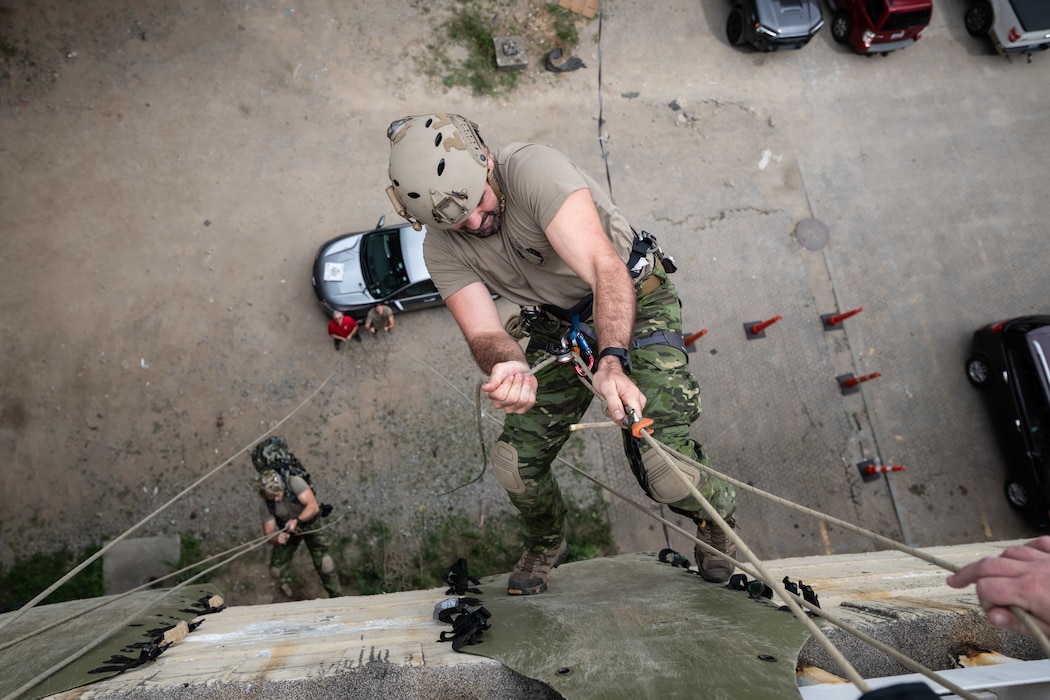 A U.S. Air Force pararescueman executes an urban high-angle ropes scenario to reach a simulated injured service member, render medical care, and lower him to safety during the 2023 PJ Rodeo competition in Louisville, Ky., Sept. 6, 2023. The biennial event, which tests the capabilities of pararescue Airmen across the service, was hosted by the Kentucky Air National Guard’s 123rd Special Tactics Squadron. (U.S. Air National Guard photo by Dale Greer)