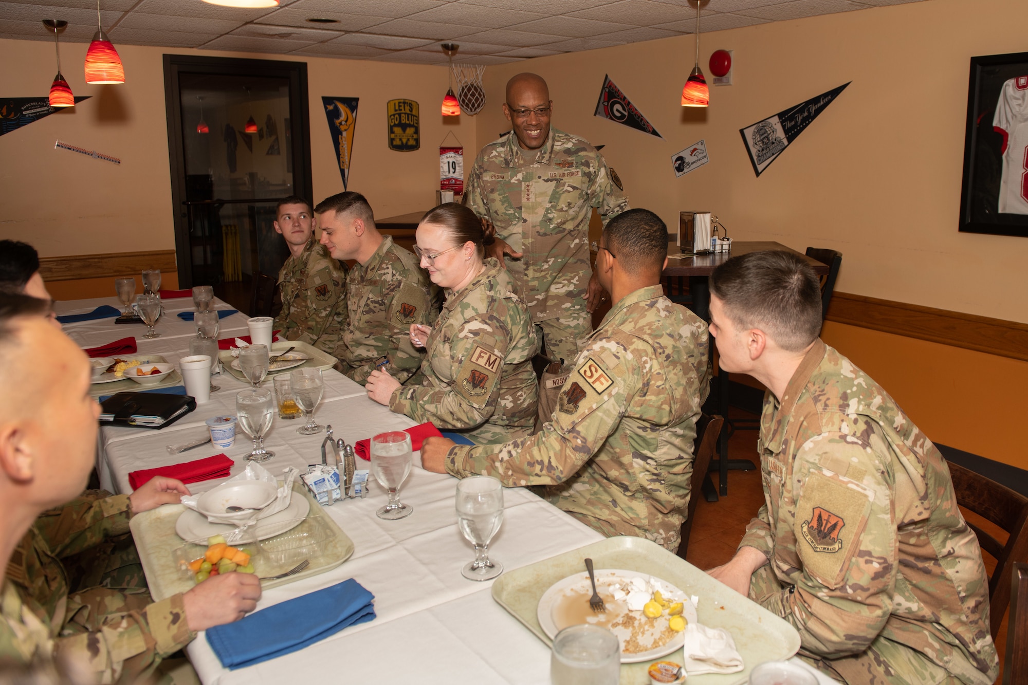 CSAF greets Airmen seated at table.