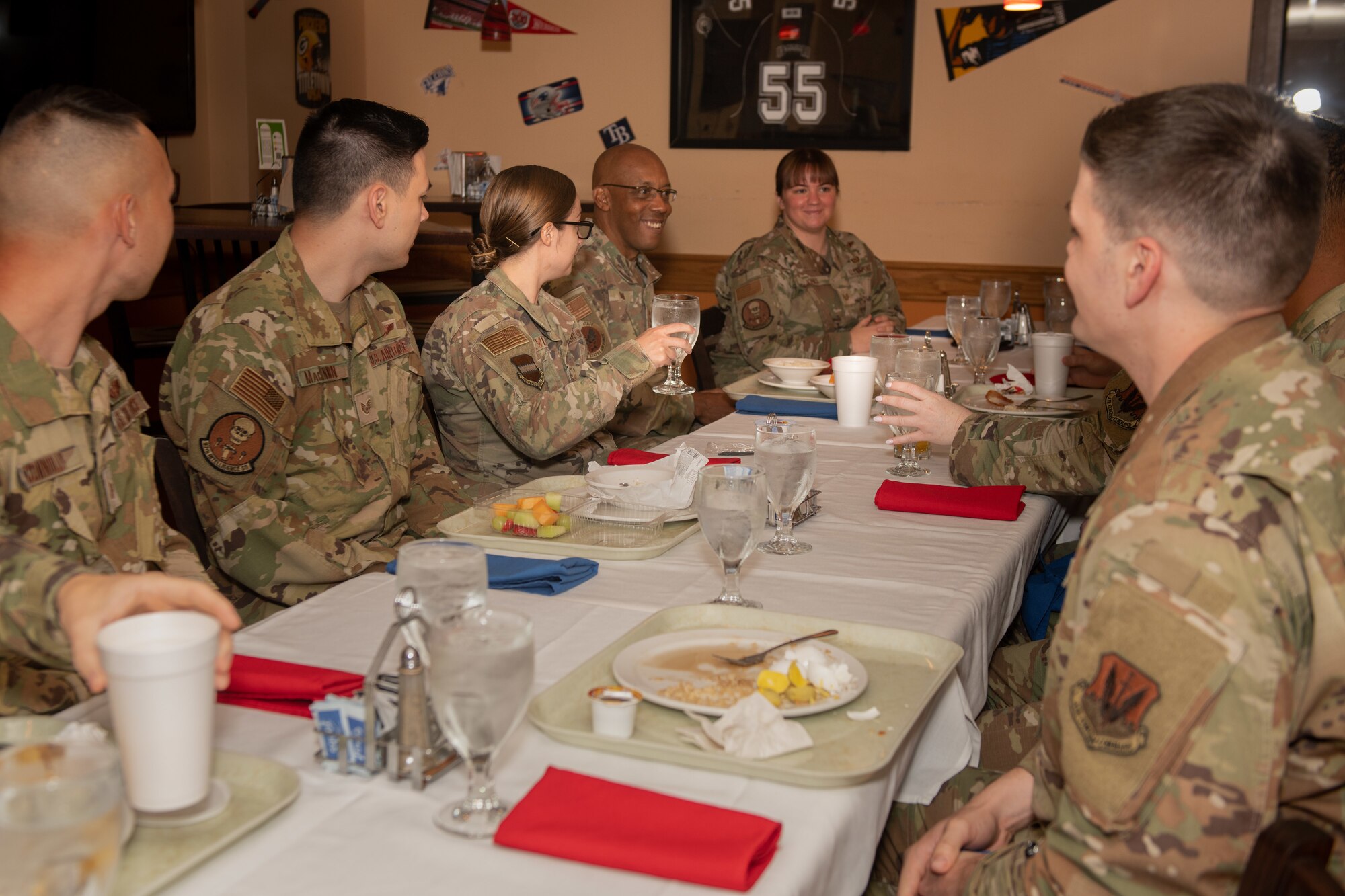 CSAF and Airmen talking and eating meal together at table.