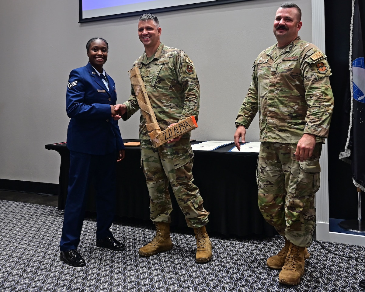 U.S. Air Force Senior Airman Shantell Mayes, Class 23-F Airman Leadership School graduate, presents the “L” to a group of first sergeants belonging to the 17th Training Wing during the Class 23-F ALS graduation at the Powell Event Center, Goodfellow Air Force Base, Texas, Sept. 7, 2023. Every ALS class plays a volleyball game with the first sergeants and the winning team presents the “L” to the losing team at graduation. (U.S. Air Force photo by Airman 1st Class Zach Heimbuch)