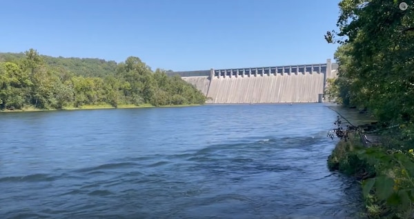 river with woods and dam in the background