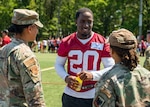 Jartavius Martin, center, defensive back, Washington Commanders football team, speaks to U.S. Air Force Master Sgt. Tatiana Collins, left, Air National Guard (ANG) marketing and advertising non-commissioned officer, National Guard Bureau (NGB), and Master Sgt. Jasmine Grant, ANG events NCO, NGB, during an open practice held at Joint Base Andrews, Maryland, Aug. 25, 2023. As part of a partnership between the Washington Commanders and U.S. Air Force, an Air National Guard patch will be featured on the Commanders defensive players’ practice jerseys this season to help garner exposure for recruiting the next generation of Airmen.