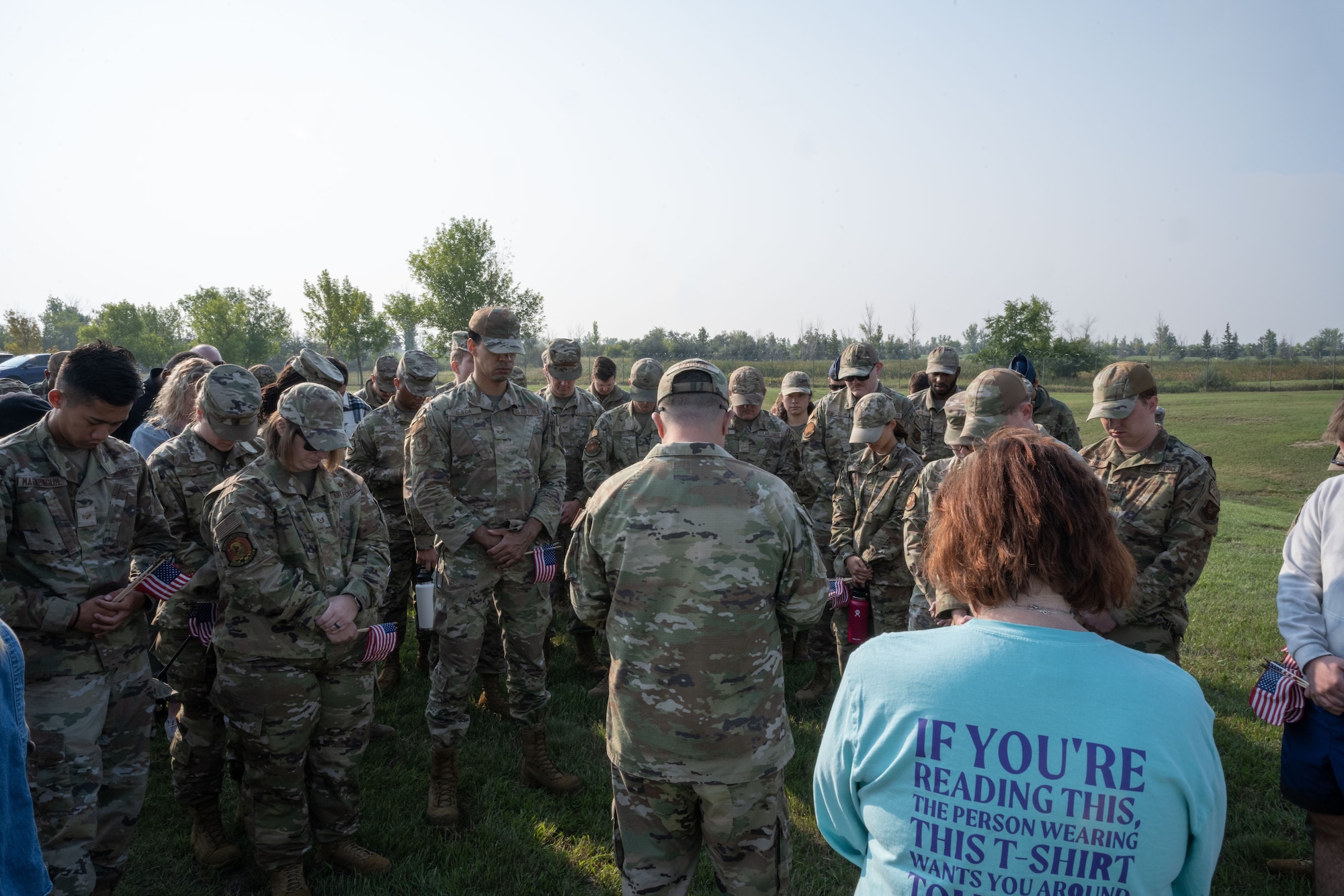 Team Minot Airmen and civilians from bow their heads during a moment of silence at Minot Air Force Base, North Dakota, Sept. 6, 2023. Team Minot came together to remember the 358 service members that committed suicide last year. (U.S. Air Force photo by Airman 1st Class Trust Tate)