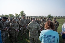 Team Minot Airmen and civilians from bow their heads during a moment of silence at Minot Air Force Base, North Dakota, Sept. 6, 2023. Team Minot came together to remember the 358 service members that committed suicide last year. (U.S. Air Force photo by Airman 1st Class Trust Tate)