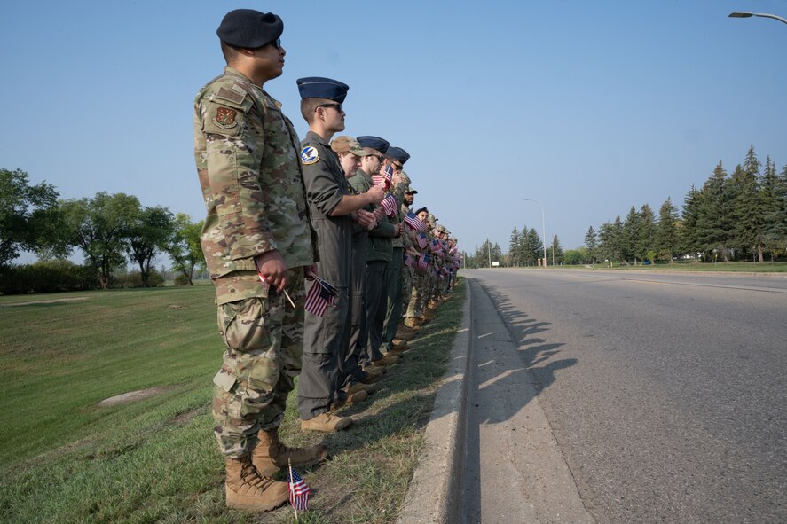 Team Minot Airmen line up shoulder-to-shoulder in preparation of planting flags at Minot Air Force Base, North Dakota, Sept. 6, 2023. The Airman volunteered to plant the flags for the third annual flag planting ceremony for Suicide Prevention Month. (U.S. Air Force photo by Airman 1st Class Trust Tate)