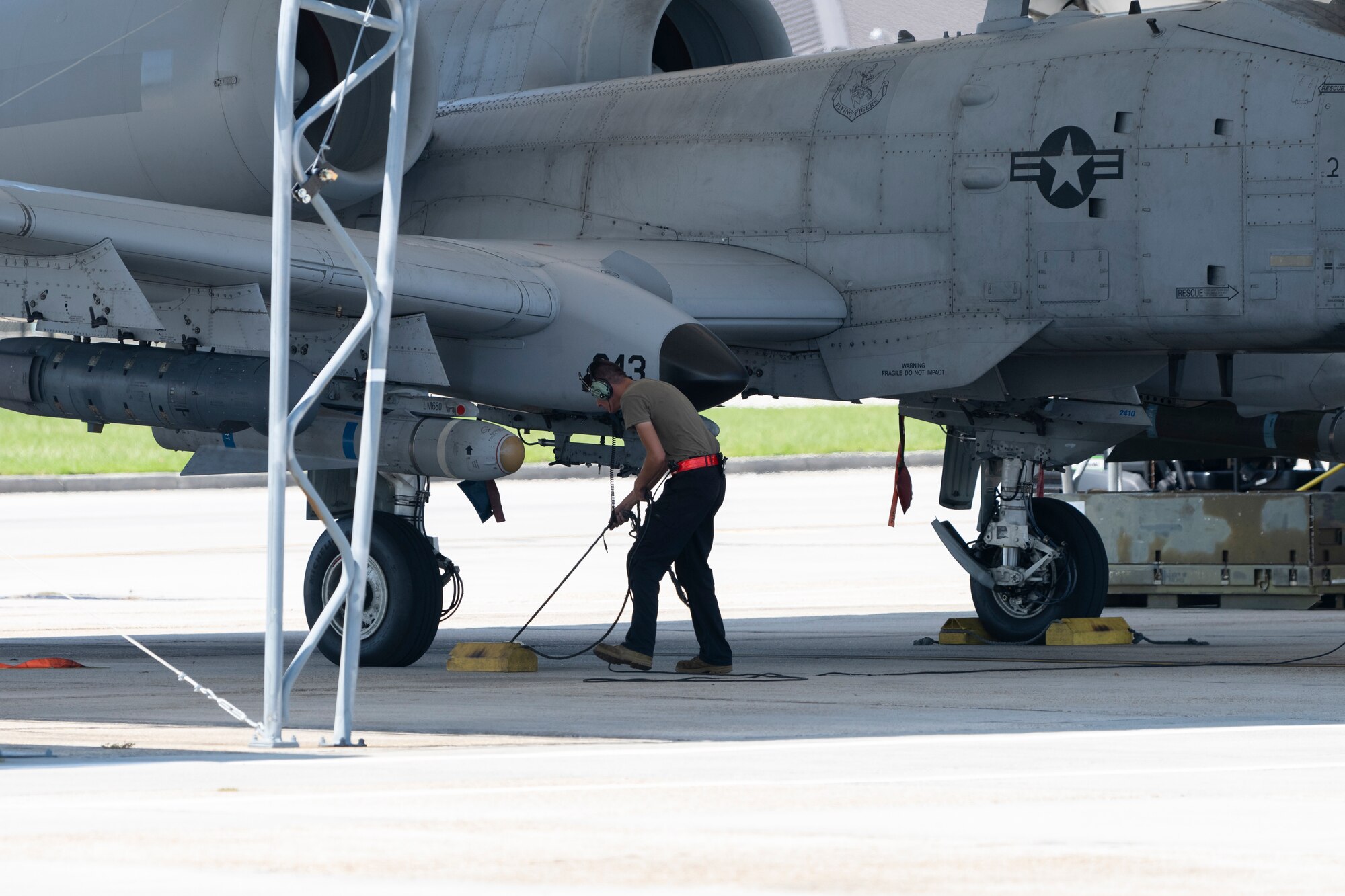 Airman removes blocks from A-10 wheels before take off