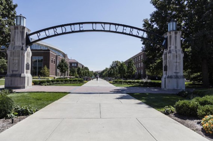 An archway reading "Purdue University" stands above a long walkway.