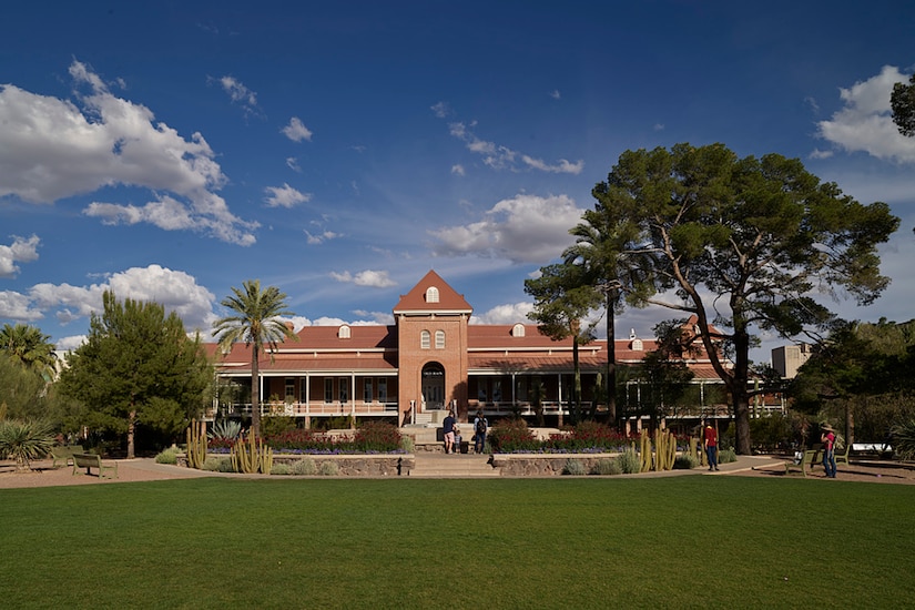 Wide shot of a building behind a grassy area.