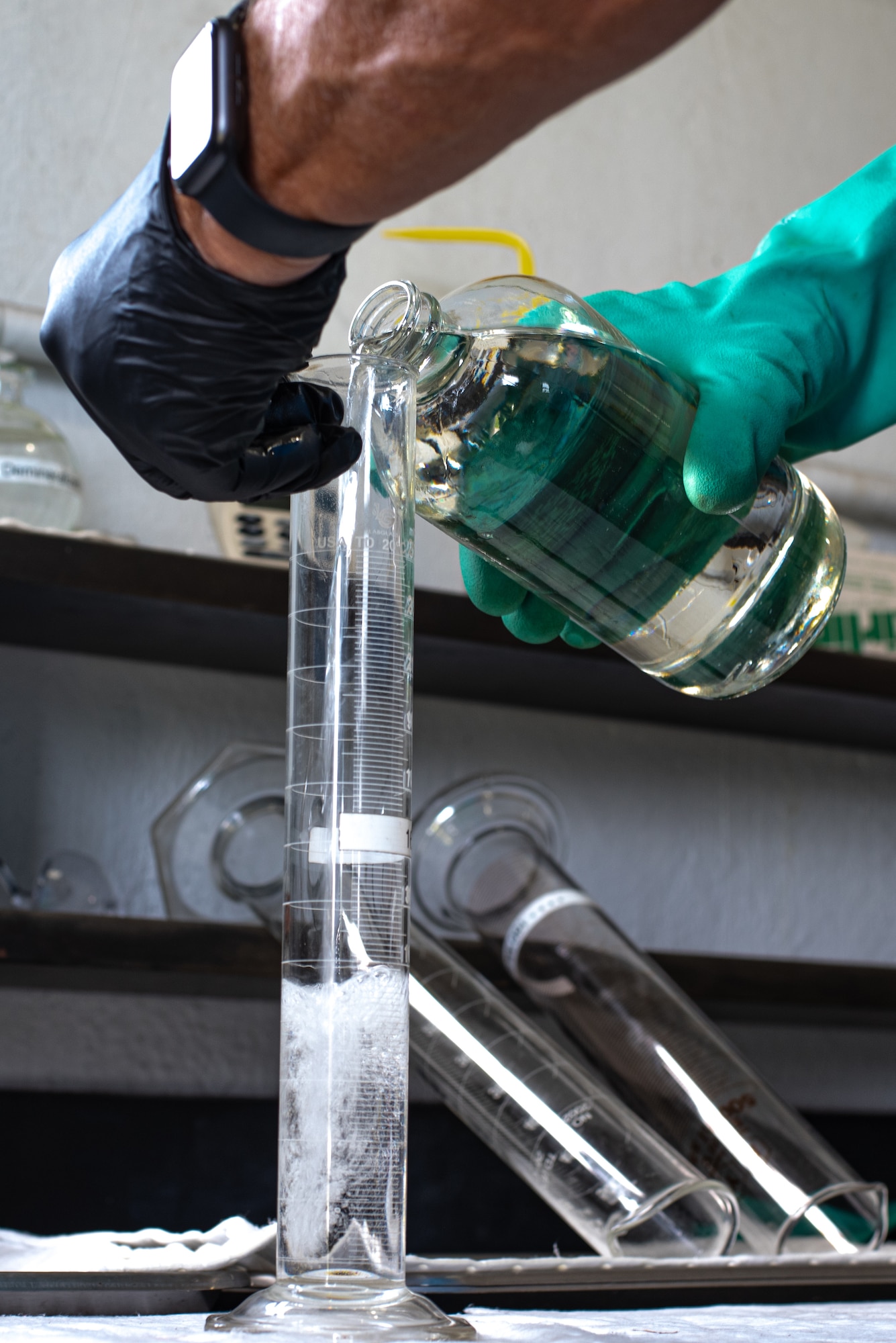 Bill Campbell, SIEGE Enterprises fuel distribution system operator, pours a sample of jet fuel into a graduated cylinder, at MacDill Air Force Base, Florida, August 22, 2023.