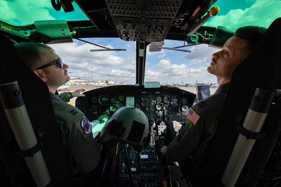Two UH-1N pilots perform flight checks.