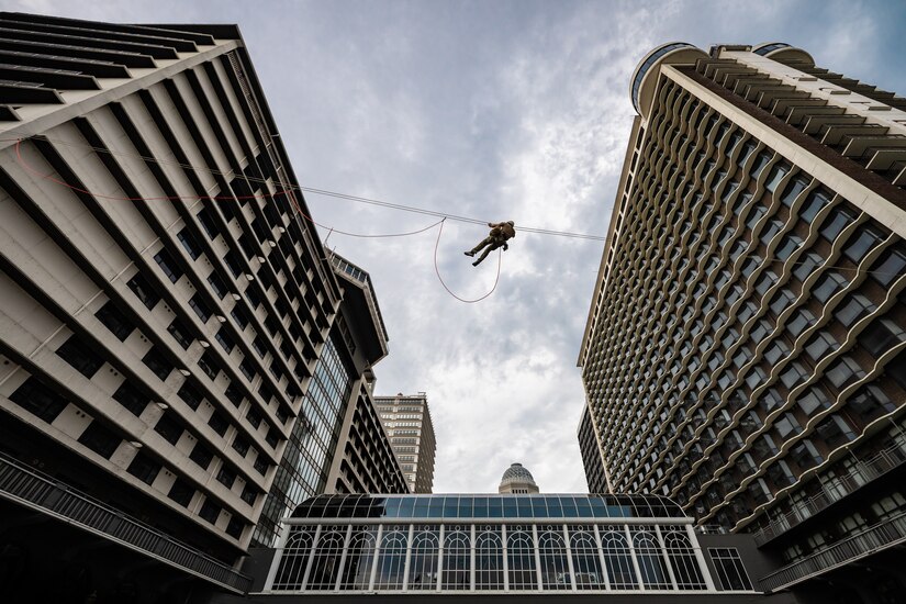 A U.S. Air Force pararescueman executes an urban high-angle ropes scenario to reach a simulated injured service member, render medical care, and lower him to safety during the 2023 PJ Rodeo competition in Louisville, Ky., Sept. 6, 2023. The biennial event, which tests the capabilities of pararescue Airmen across the service, was hosted by the Kentucky Air National Guard’s 123rd Special Tactics Squadron. (U.S. Air National Guard photo by Dale Greer)