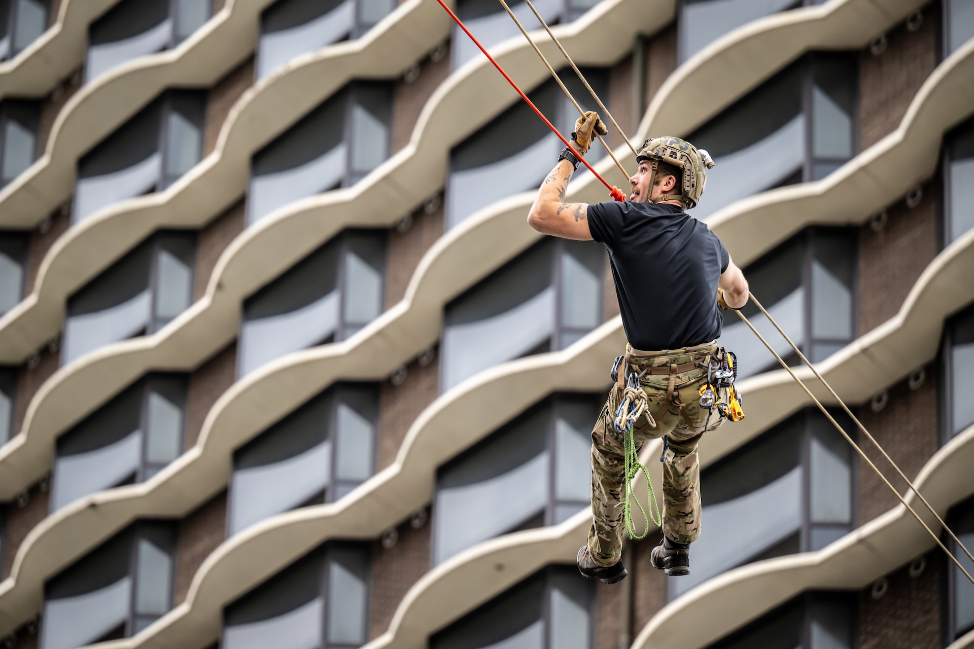A U.S. Air Force pararescueman executes an urban high-angle ropes scenario to reach a simulated injured service member, render medical care, and lower him to safety during the 2023 PJ Rodeo competition in Louisville, Ky., Sept. 6, 2023. The biennial event, which tests the capabilities of pararescue Airmen across the service, was hosted by the Kentucky Air National Guard’s 123rd Special Tactics Squadron. (U.S. Air National Guard photo by Dale Greer)