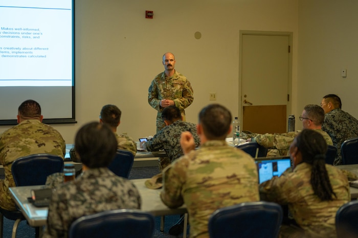 Senior Master Sgt. Kyle Rollins  speaks with U.S. Airmen and Koku Jieitai attending the SNCO Professional enhancement seminar.