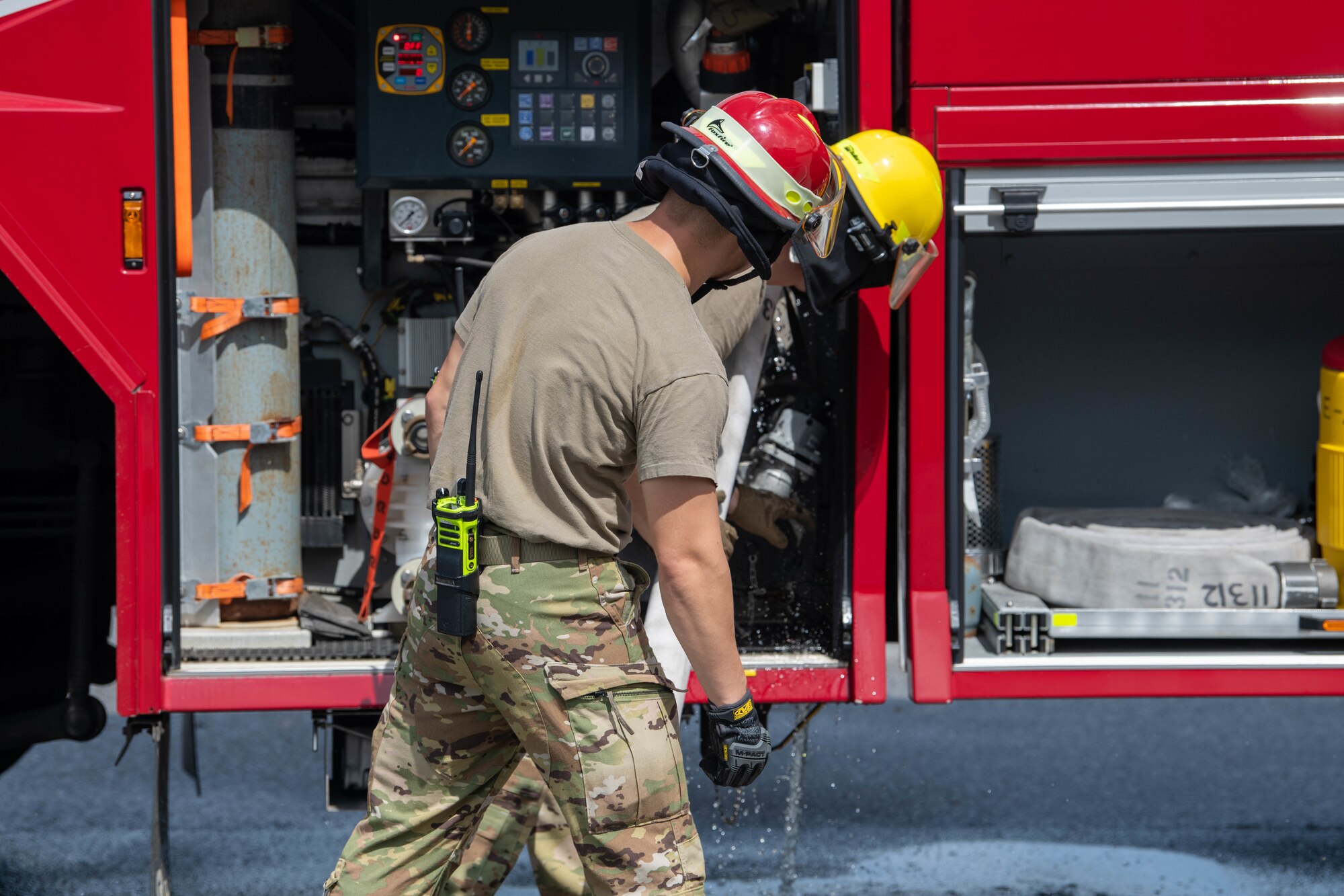 18th CES firemen inspect a water tanker after over filling
