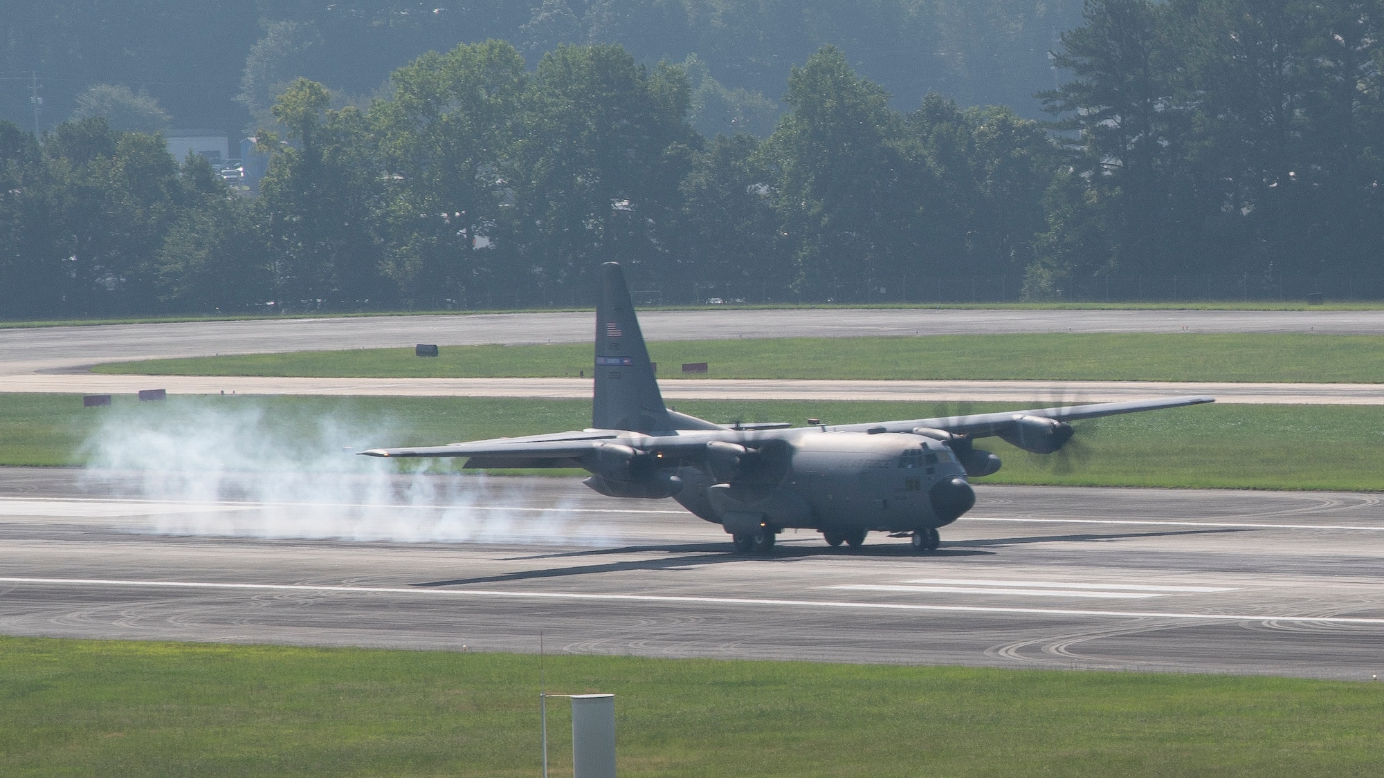 A C-130H3 Hercules lands on a flightline