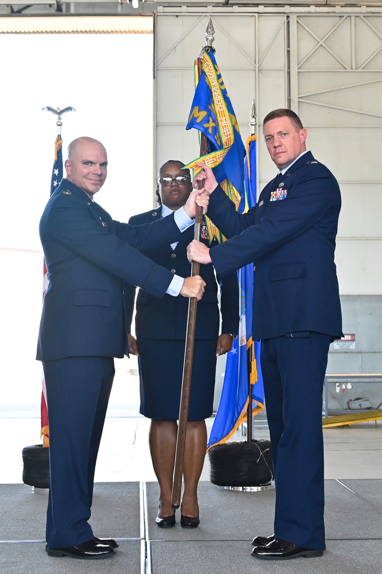Airmen hold flag on stage