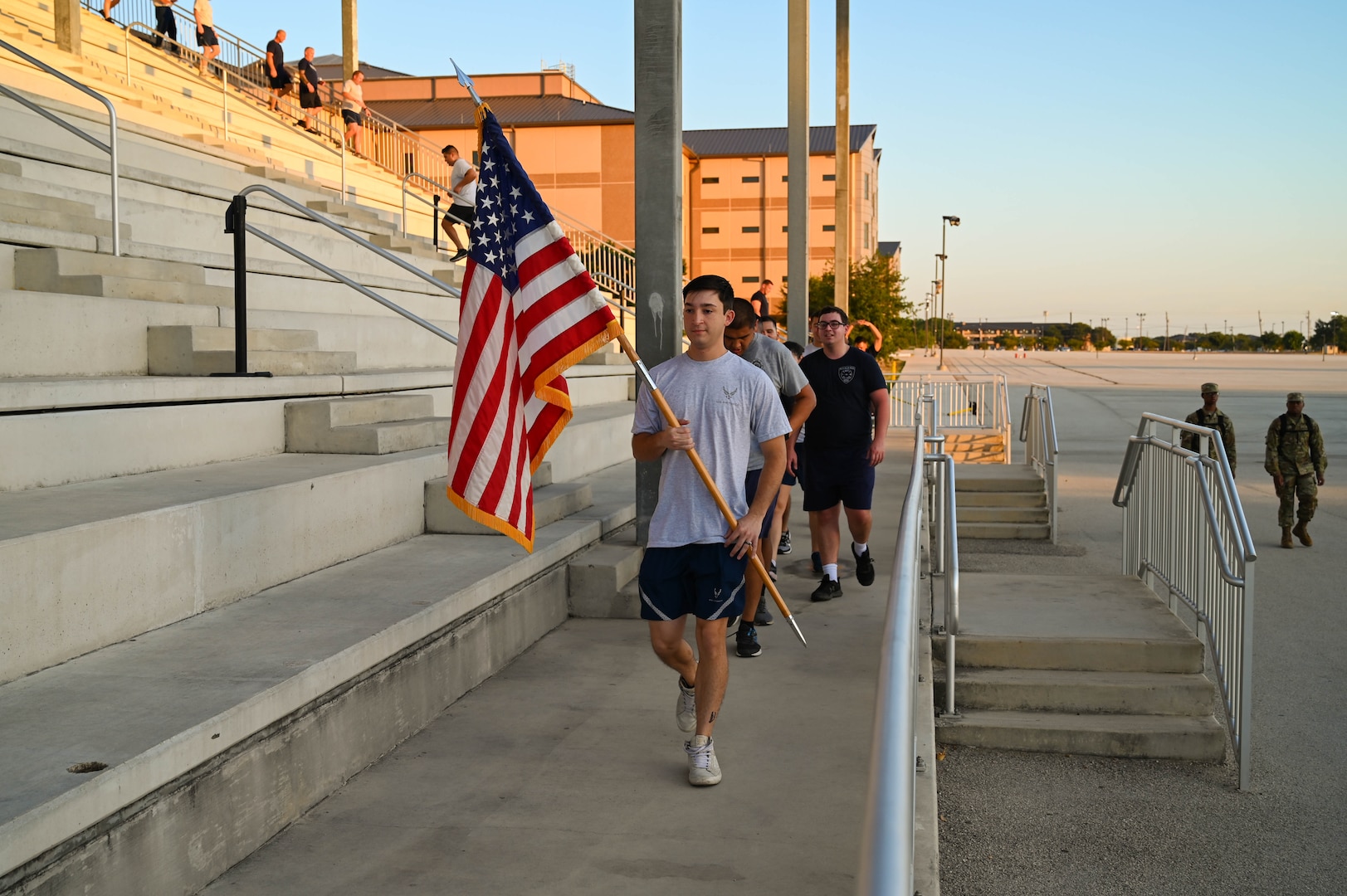 Senior Airman Hunter Sykes, a 433rd Civil Engineering Squadron firefighter, takes his turn serving as the flagbearer during the unit’s annual 9/11 Memorial Stair Climb outside the Pfingston Reception Center on Joint Base San Antonio-Lackland, Texas on Sep. 10, 2023.