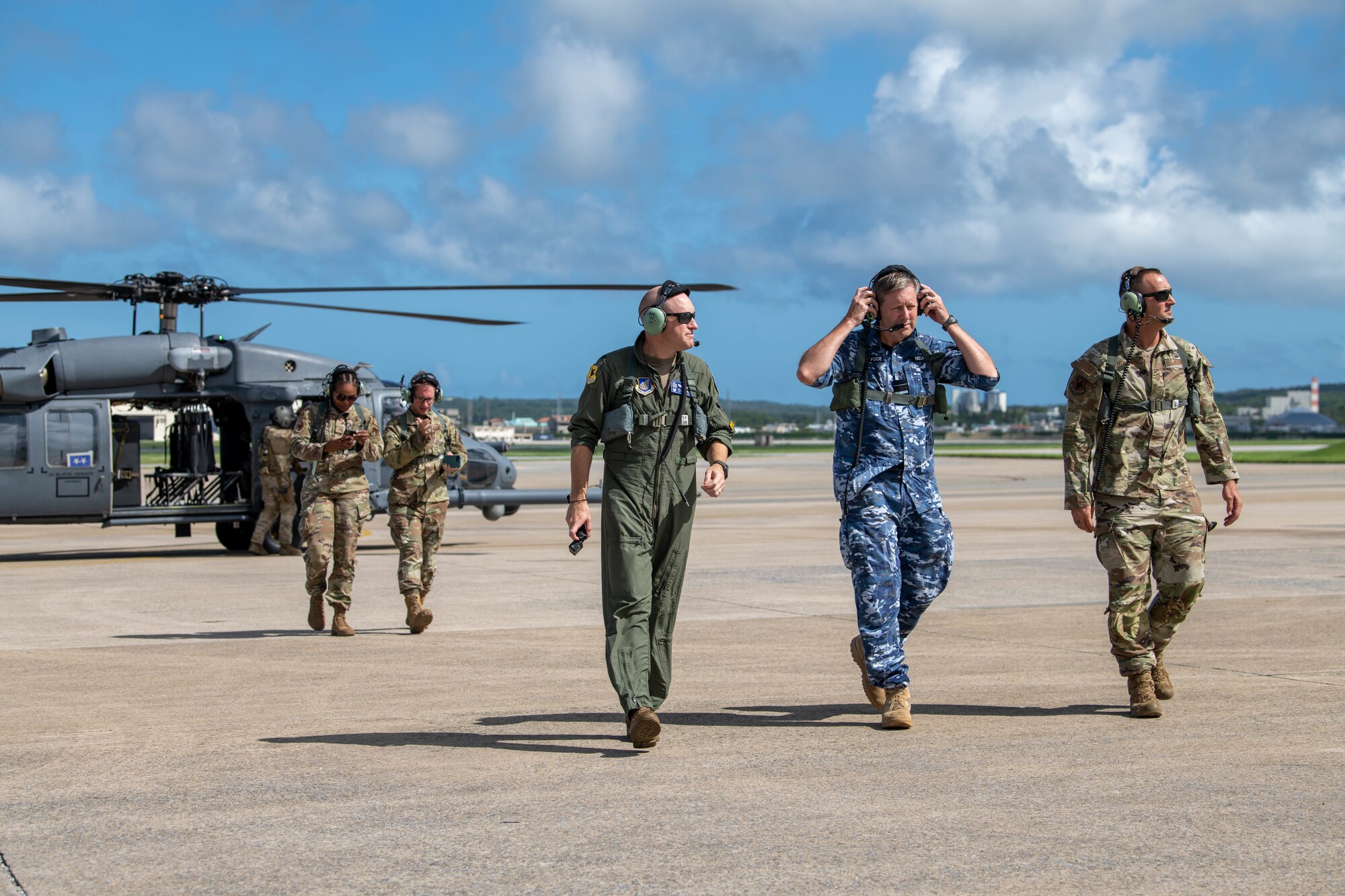 Wing commanders and distinguished visitor walk away from helicopter