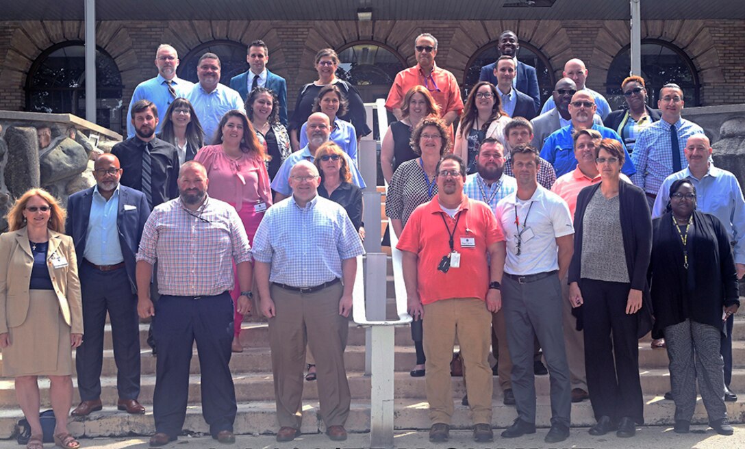 A group of people stand on some stairs and pose for a group photo.
