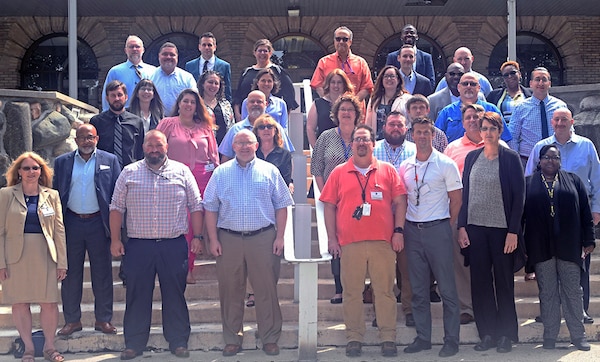 A group of people stand on some stairs and pose for a group photo.
