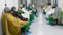 Two rows of patients sit in the pre-op waiting around as they await their scheduled cataract and pterygium surgeries.