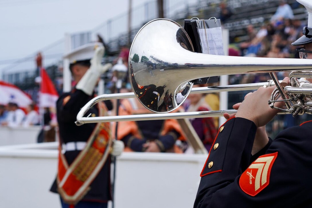 A Marine Drum Major in the dress uniform conducts the band.