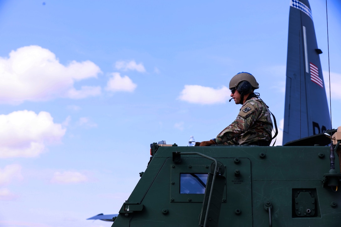A soldier sits in a High Mobility Artillery Rocket System vehicle.