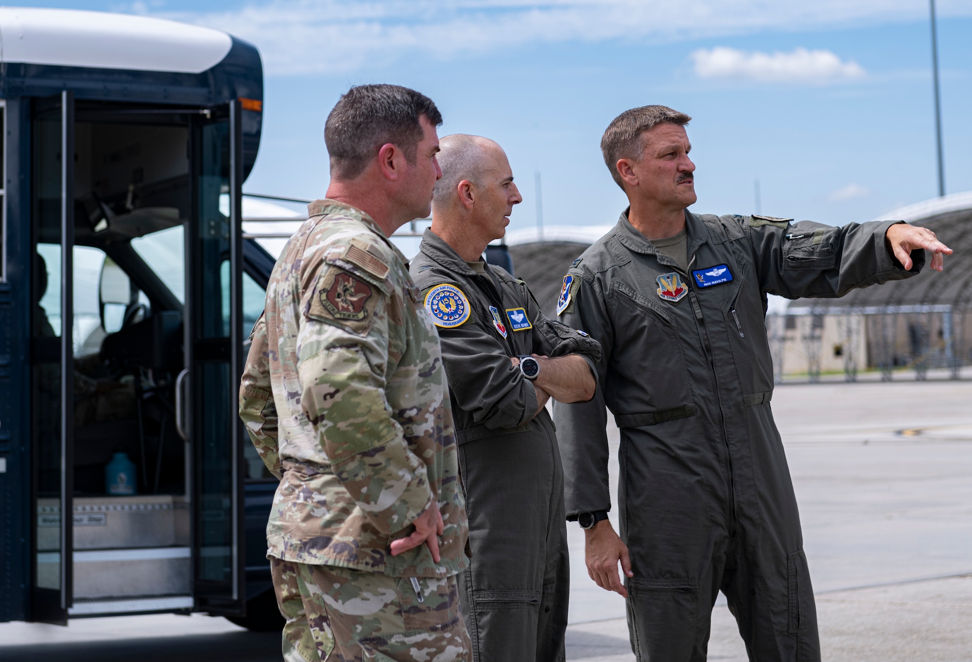 Three Airmen look at damage done from a hurricane