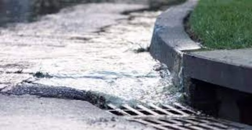 Water drains into a storm drain.