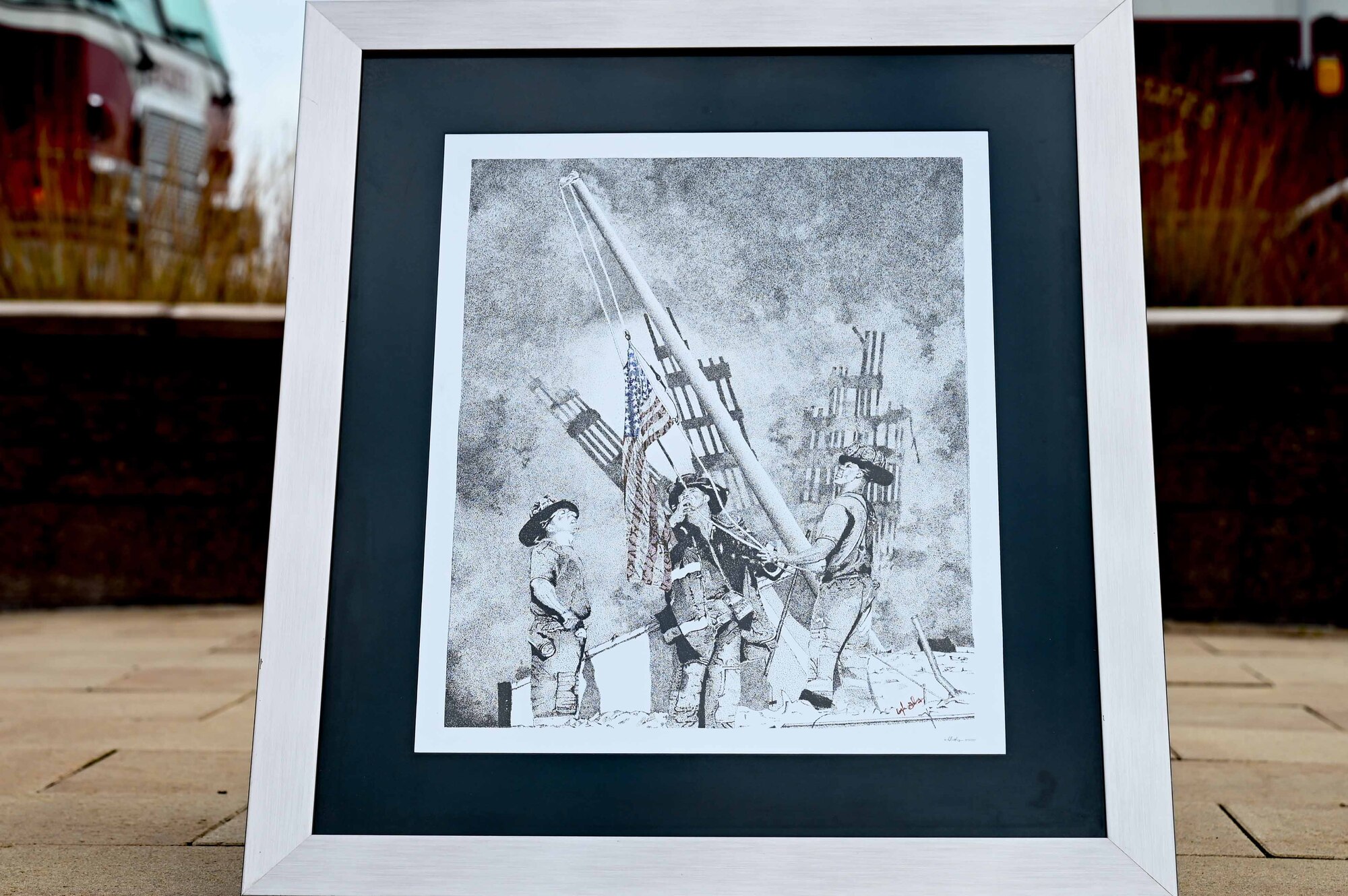 A photo portraying the depiction of first responders during the 9/11 attacks is displayed.