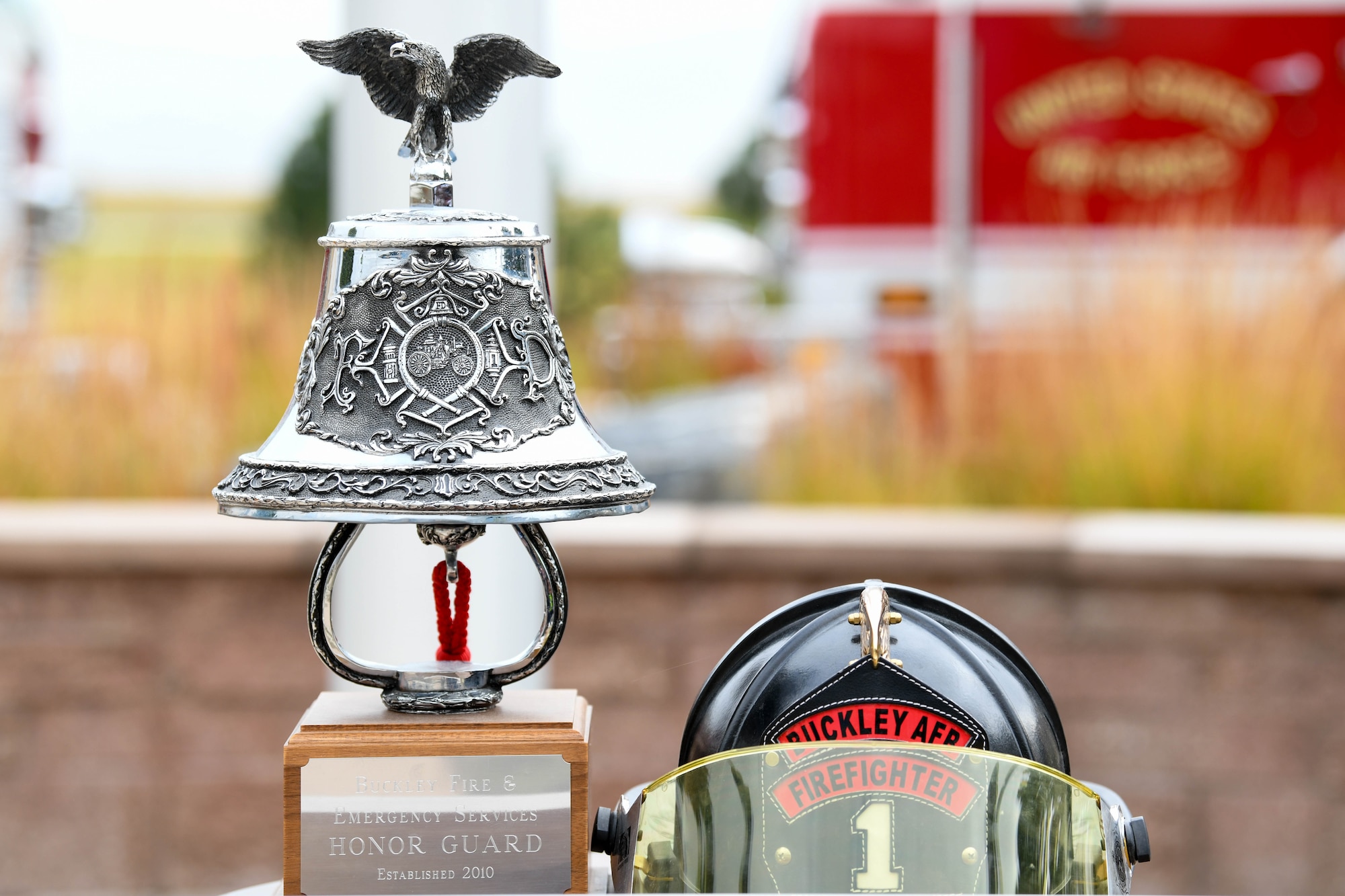 A bell and a firefighter helmet sit on a display.