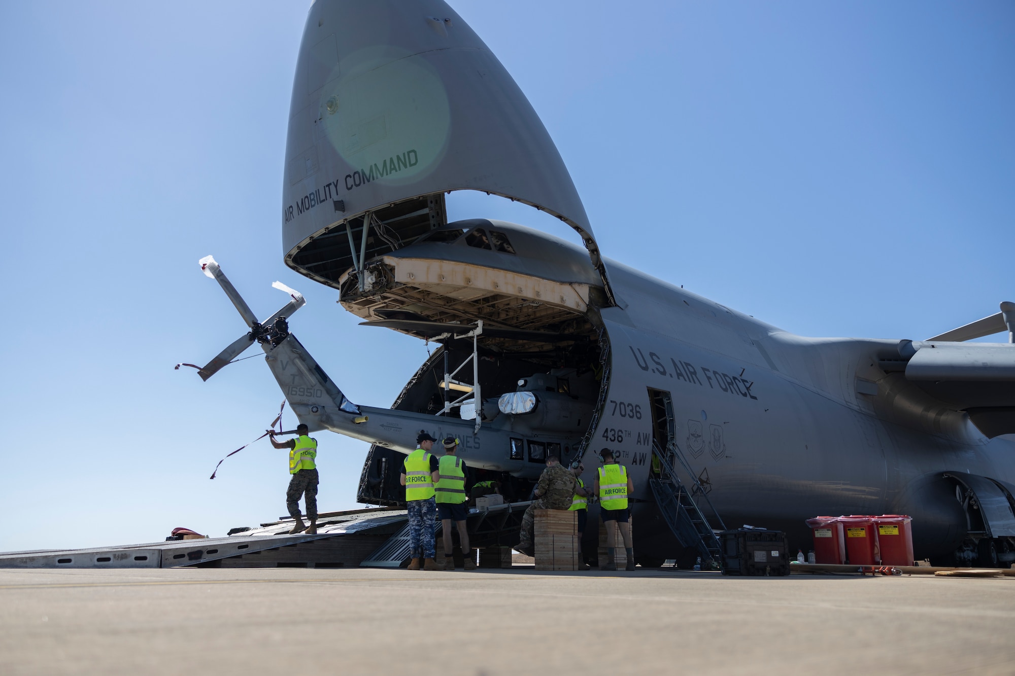U.S. Marines with Marine Rotational Force – Darwin 23, U.S. Airmen, and Royal Australian Air Force Airmen offload an AH-1Z Viper helicopter with Marine Light Attack Helicopter Squadron 367 from a U.S. Air Force C-5M Super Galaxy with the 436th Airlift Wing at Royal Australian Air Force Base Darwin, Northern Territory, Australia, July 13, 2023. The C-5M transported U.S. Marine Corps attack helicopters to Darwin to allow forward air control in aerial and ground escort operations in order to maintain a crisis and contingency-ready force that can contribute to a free and open Indo-Pacific region. (U.S. Marine Corps photo by Cpl. Adeola Adetimehin)