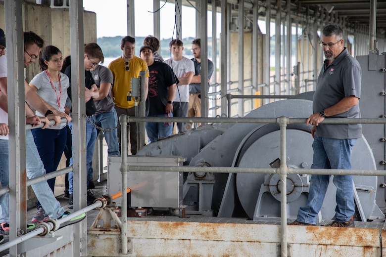 Summer interns stand over the Tainter gate spillway at the Gavins Point Dam on July 14, 2023 near Yankton, S.D.