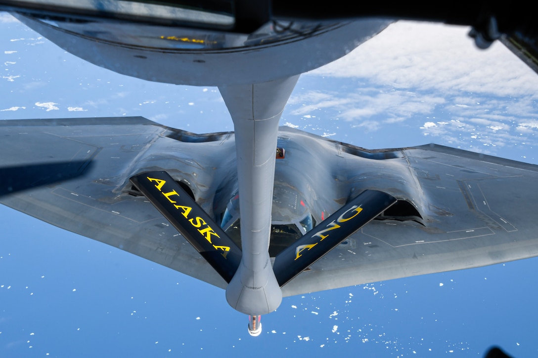 A stealth bomber gets refueled in midair.