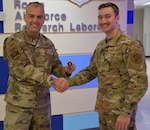 Air Force Major General Edward Vaughan, director of space operations for the National Guard Bureau, presents a challenge coin to New York Air National Guard Senior Airman Max Dean, during a visit to the Airmen of the 222nd Command and Control Squadron in Rome, New York on Sept. 9, 2023.