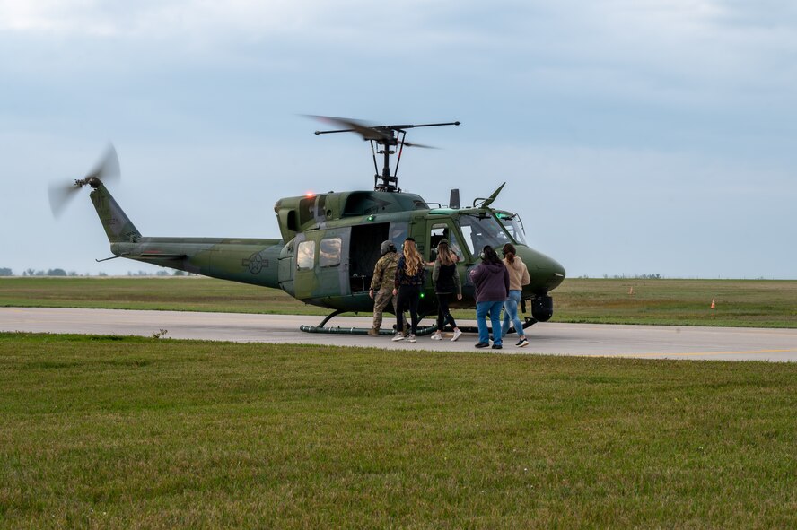 Aircrew with the 54th Helicopter Squadron (HS) load a UH-1N Iroquois ,“Huey”, with passengers for a spouse orientation flight at Minot Air Force Base, North Dakota, Sept. 9, 2023. During the orientation flight, the 54th HS provided spouses a first-hand experience of the mission and demonstrated how the unit conducts global deterrence missions. (U.S. Air Force photo by Airman 1st Class Alexander Nottingham)