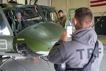 A 91st Missile Security Operations Squadron tactical response force member takes a picture of his spouse during a spouse orientation flight at Minot Air Force Base, North Dakota, Sept. 9, 2023. During the orientation flight, the 54th HS provided spouses a first-hand experience of the mission and demonstrated how the unit conducts global deterrence missions. (U.S. Air Force photo by Airman 1st Class Alexander Nottingham)