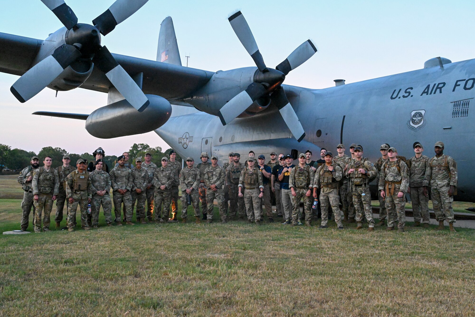 Airmen pose for a photo in front of an aircraft static.
