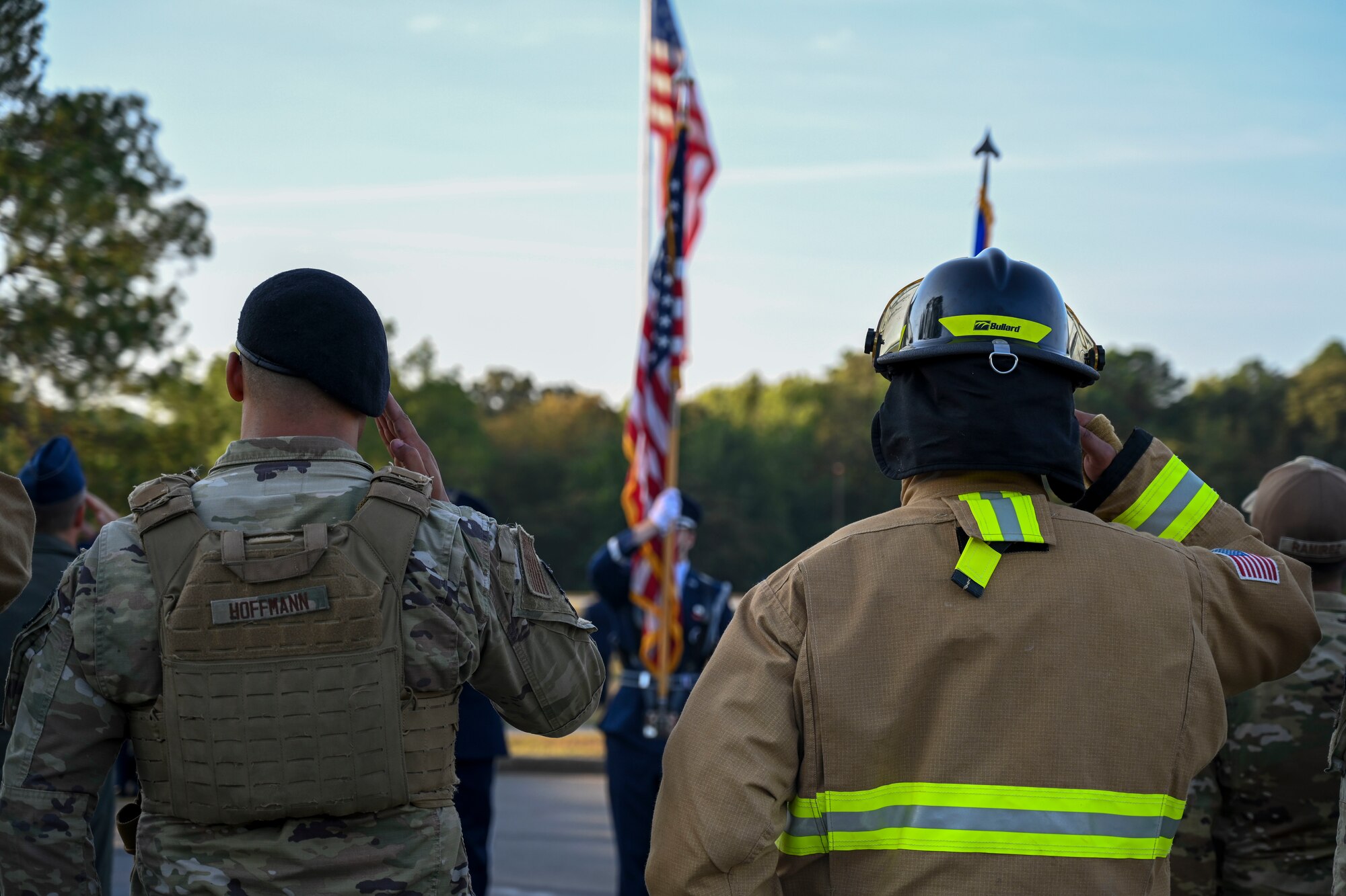 Airmen salute a flag.