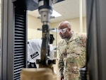 man in uniform wears safety goggles in laboratory