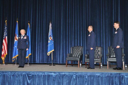 three people stand during a ceremony